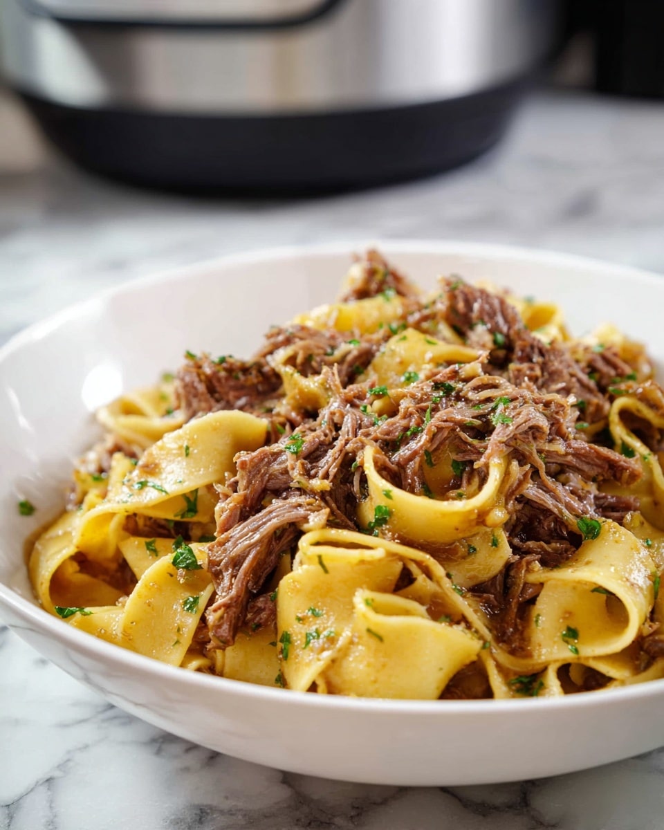 This image shows a close-up of a black slow cooker filled with wide yellow pasta noodles mixed with shredded brown meat. The noodles have a soft, slightly curly texture, and the meat looks tender and juicy, evenly spread throughout the pasta. The inside rim of the slow cooker is shiny and smooth. The slow cooker sits on a white marbled surface, and a white cloth with blue stripes is partly visible on the side. The lighting highlights the glossiness of the noodles and meat, creating a warm, inviting look. photo taken with an iphone --ar 4:5 --v 7