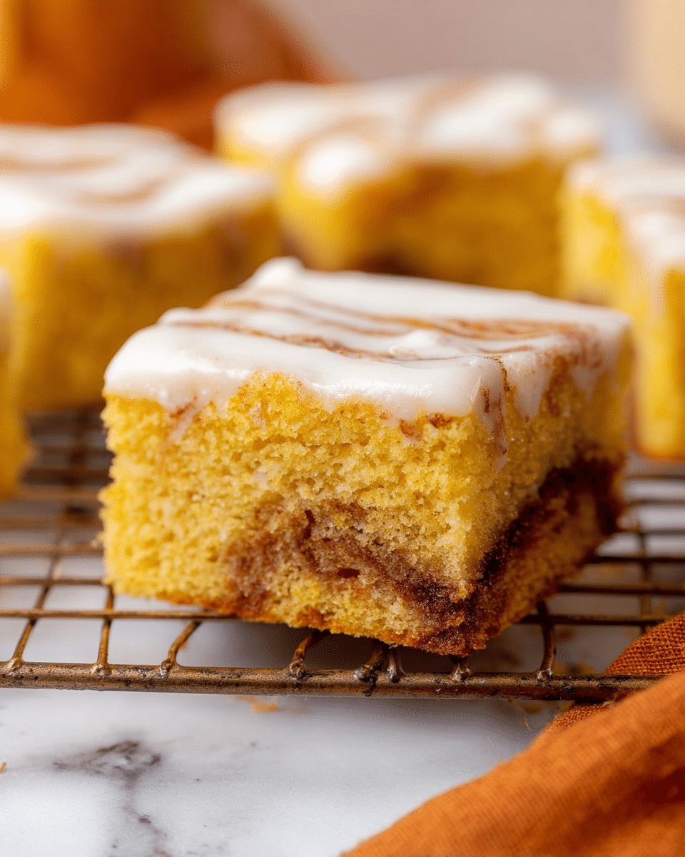The image shows a close-up of a thick square slice of yellow cake with a rich brown swirl layer near the bottom. The cake has a soft, moist texture with a smooth, white icing layer evenly spread on top. The slice is placed on a wire rack with a few other slices blurred in the background. The surface underneath has a white marbled texture, and an orange cloth is partly visible in the corner. Photo taken with an iphone --ar 4:5 --v 7