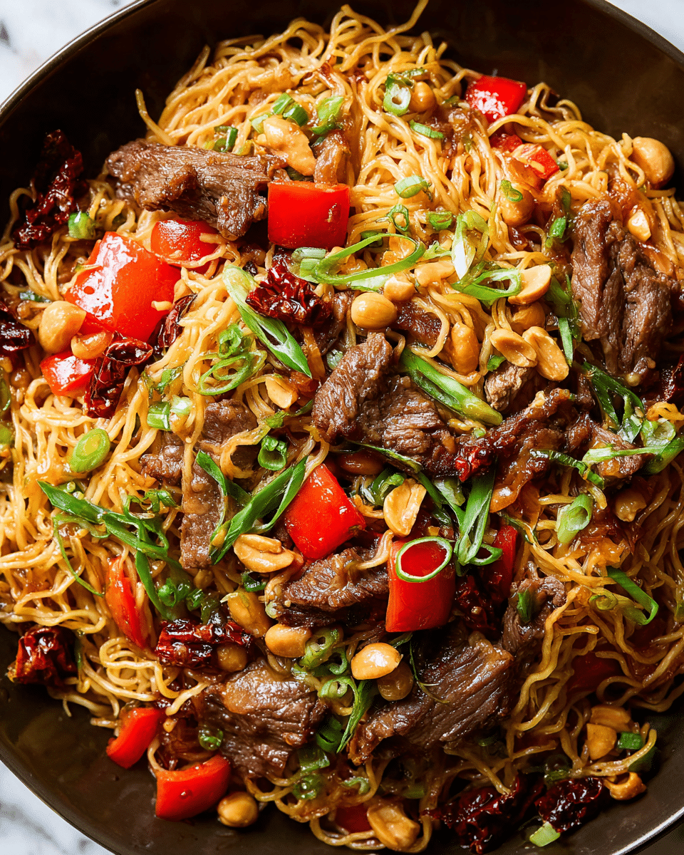 The image shows a close-up of a stir-fried noodle dish with several layers and colors. The bottom layer consists of thin, golden-yellow noodles mixed tightly with darker brown, cooked slices of beef. Scattered throughout the noodles and beef are bright red bell pepper cubes adding a vibrant color contrast. Small beige peanuts are spread evenly, giving a crunchy texture. Thin slices of green onions are sprinkled on top for a fresh green accent. Pieces of dried red chili add small dark red spots, enhancing the dish's spiced look. The whole dish appears glossy from a light sauce coating all ingredients, making them shiny. The background is a white marbled texture. photo taken with an iphone --ar 4:5 --v 7