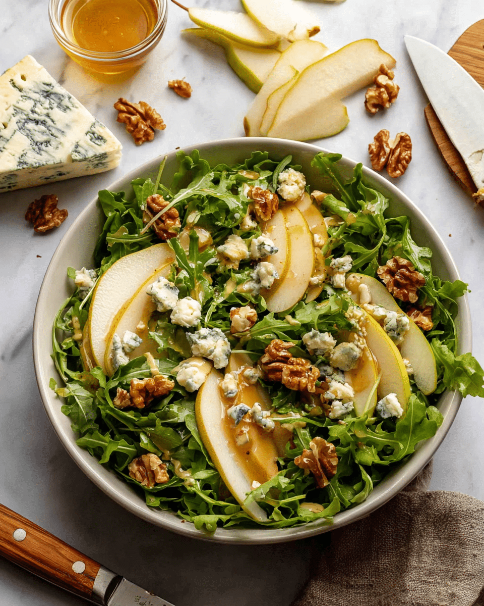A white bowl filled with a fresh salad on a white marbled surface, starting with a base layer of bright green arugula leaves, topped with thin slices of pale yellow pear with brown edges, scattered light brown walnut pieces, and chunky bits of creamy blue cheese with blue veins. The salad is drizzled with a light golden dressing. Around the bowl, there is a small glass container with a block of blue cheese, a few pear slices, a partial pear half, and a knife with a wooden handle. Photo taken with an iphone --ar 4:5 --v 7