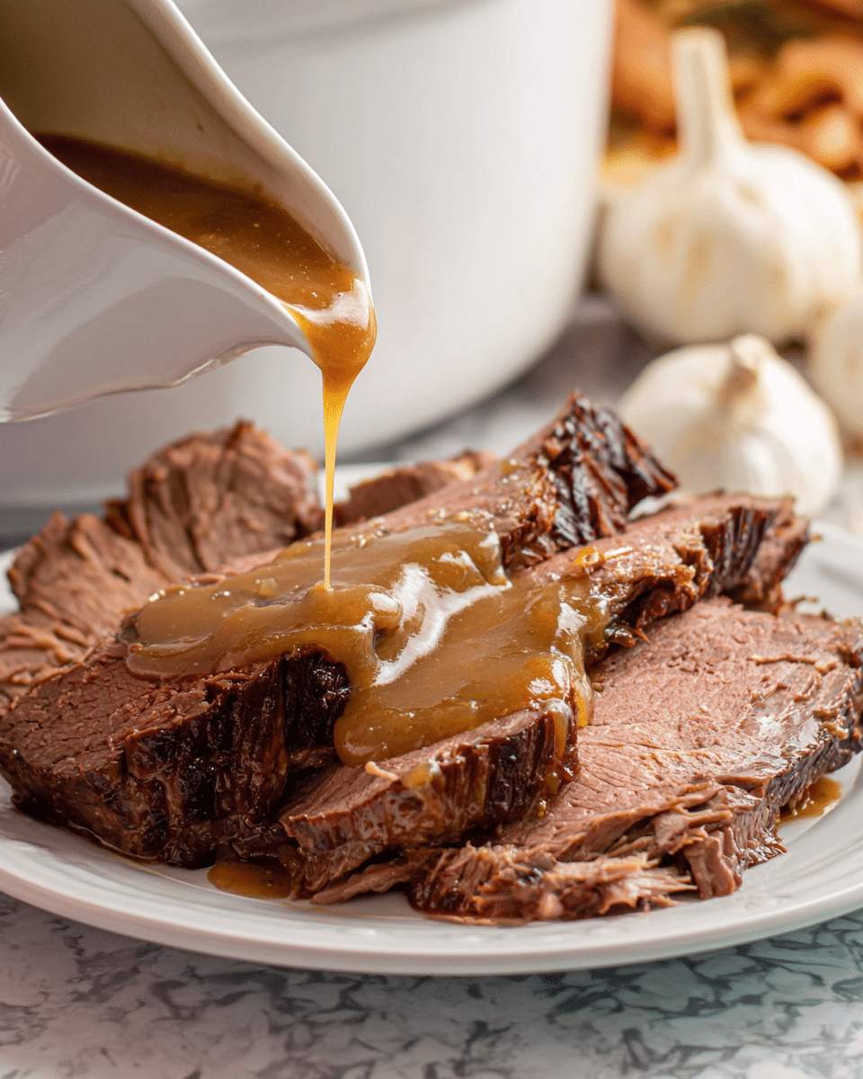 A white plate holds several thick slices of cooked beef, showing a mix of browned and pink textures, with visible fibrous details. A light brown, creamy gravy is being poured from a white gravy boat onto the beef, covering part of the top slices and creating a smooth, shiny layer over the meat. The background features a white marbled texture with whole garlic bulbs slightly out of focus, adding a rustic kitchen feel. photo taken with an iphone --ar 4:5 --v 7